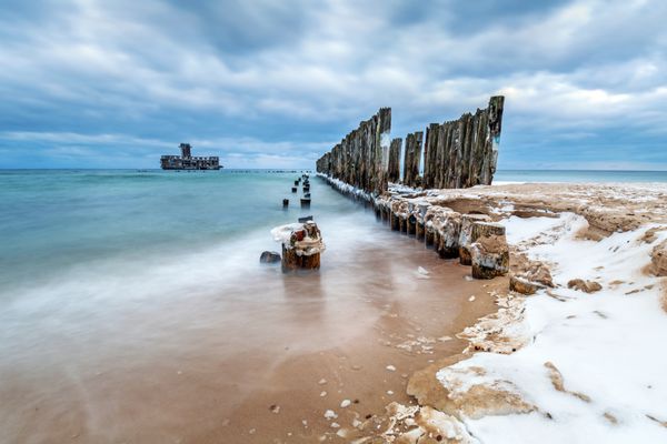 خط موج شکن های چوبی یخ زده تا سکوی اژدر جنگ جهانی دوم در دریای بالتیک بیبی دالی لهستان