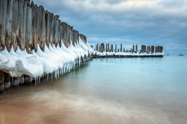 خط موج شکن های چوبی یخ زده تا سکوی اژدر جنگ جهانی دوم در دریای بالتیک بیبی دالی لهستان