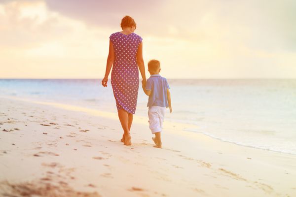 راه رفتن مادر و پسر در ساحل غروب