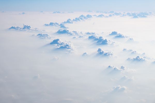 ابرها در آسمان آبی نمای هوایی از پنجره هواپیما