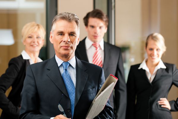 کسب و کار - تیم در یک دفتر مدیر ارشد در مقابل ایستاده است
