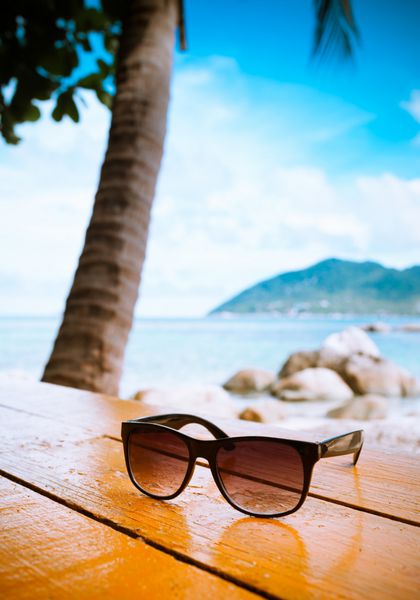 تعطیلات ساحلی نمای نزدیک از عینک آفتابی در کنار ساحل