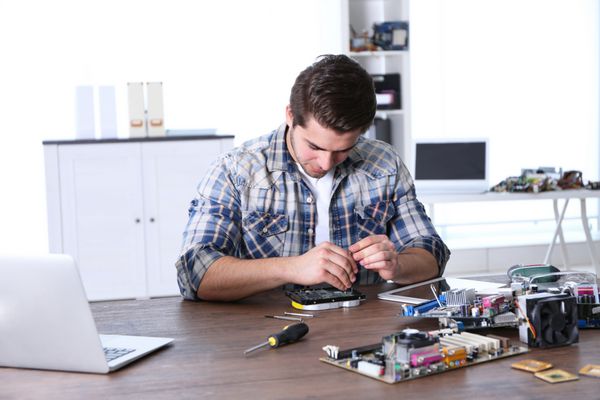 مرد تعمیر مدارهای الکترونیکی در مرکز خدمات