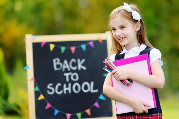 دختر بچه ناز مدرسه ای که از بازگشت به مدرسه هیجان زده است