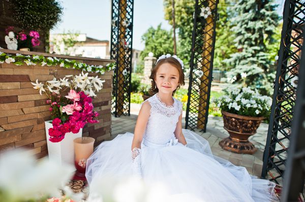 پرتره دختر کوچک ناز روی لباس سفید و تاج گل اول