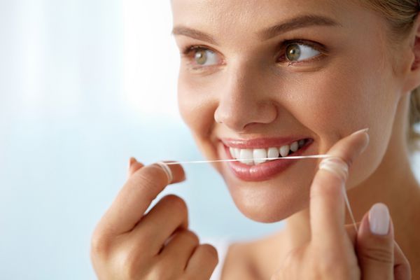 مراقبت از دندان زن زیبا و خندان با نخ دندان سفید و سالم تصویر با وضوح بالا