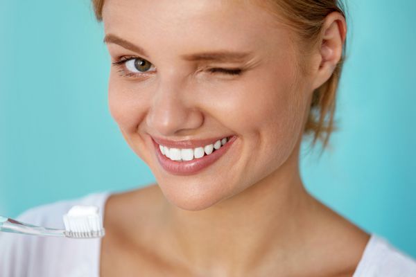 زن با لبخند زیبا دندان های سفید سالم با مسواک تصویر با وضوح بالا