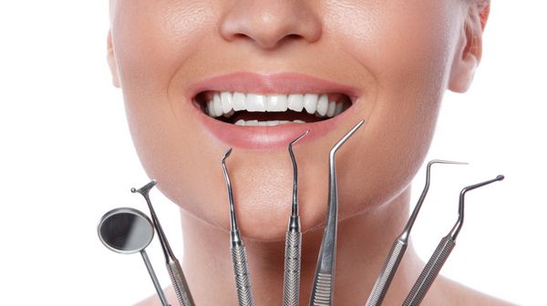 زن خندان و ابزار دندانپزشکی
