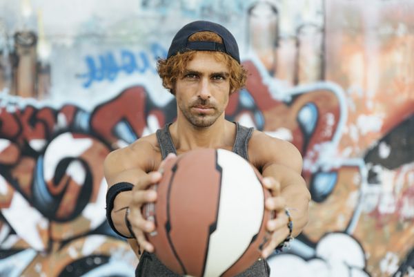 مردی با لباس ورزشی و توپ بسکتبال
