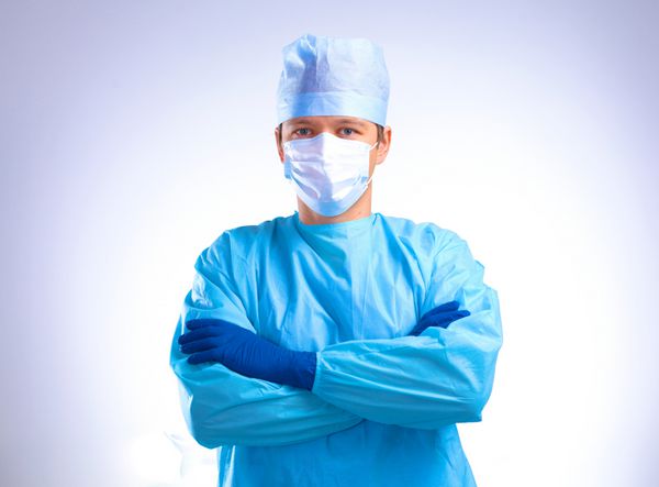 جراح در حال پوشیدن دستکش قبل از عمل نزدیک