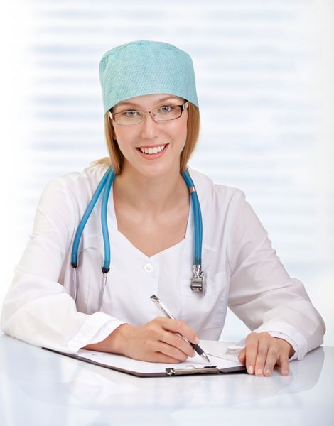 پزشک یا پرستار زن جذاب با گوشی پزشکی نشسته است