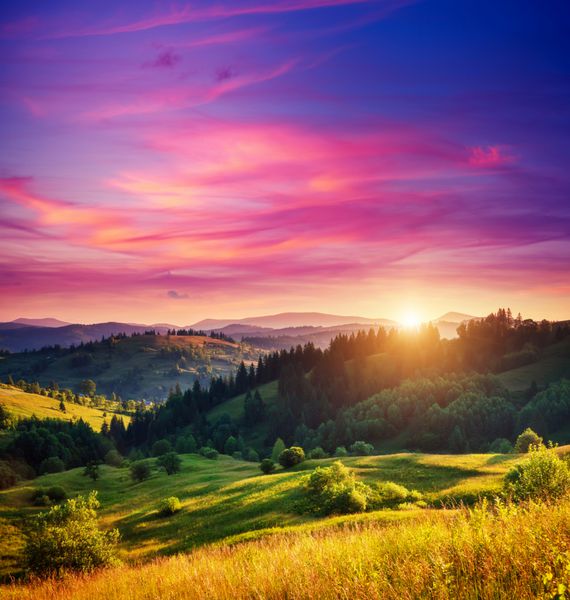 تپه های سبز زیبا که در گرگ و میش در زیر نور گرم خورشید می درخشند صحنه دراماتیک آسمان رنگارنگ ابرهای قرمز کارپات اوکراین اروپا دنیای زیبایی