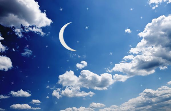 ماه نو در شب آسمان آبی با ستاره های درخشان