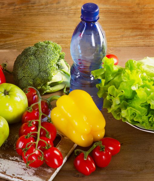 سبزیجات و میوه های تازه با بطری آب - مفهوم سلامت و رژیم غذایی