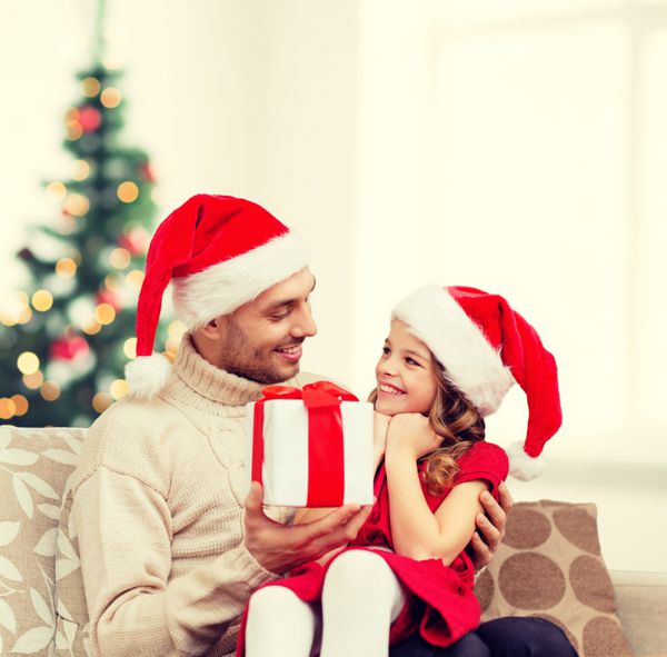 خانواده کریسمس کریسمس زمستان شادی و مفهوم مردم - پدر خندان که به دختر هدیه می دهد