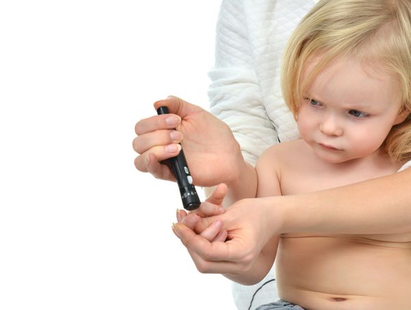 پزشک به دیابت انگشت کودک نوپا برای اندازه‌گیری قند قند خون جدا شده روی پس‌زمینه سفید