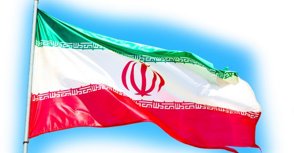 در پرچم ایران در حال تکان دادن آسمان آبی و باد