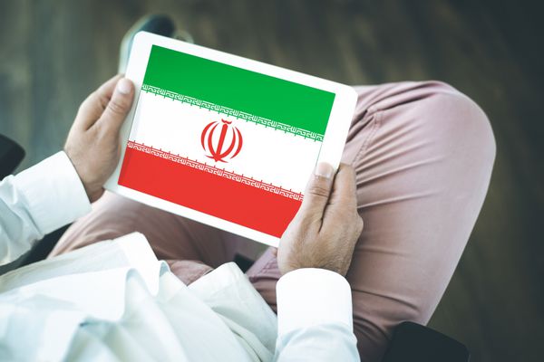 افرادی که از رایانه لوحی استفاده می کنند و پرچم ایران را روی صفحه نمایش می دهند