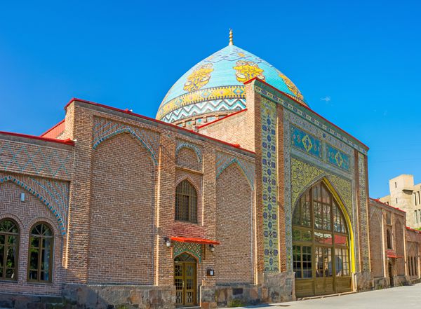 ایروان ارمنستان - 29 مه 2016 درگاه مرکزی مسجد آبی تزئین شده با نقوش اسلامی روی کاشی های لعابدار و بالای آن با گنبد کاشیکاری رنگارنگ با تزئینات پیچیده در 29 مه در ایروان