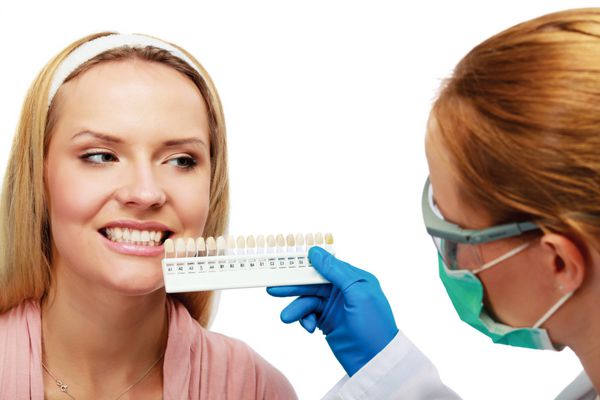 دندانپزشک در حال کار بر روی بیمار زن در مطب