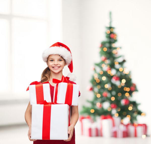 دختری با کلاه کمکی بابا نوئل با جعبه های هدیه فراوان