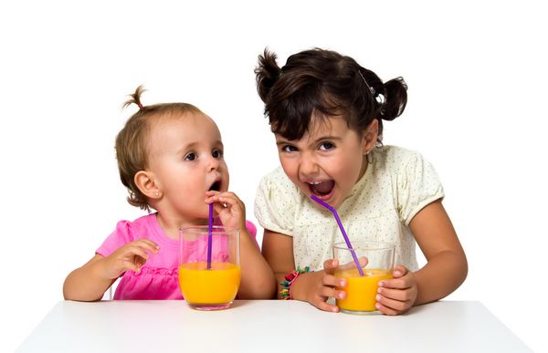 دختران کوچک در حال نوشیدن آب پرتقال