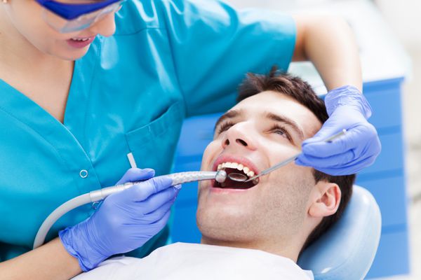 مردی که در حال معاینه دندان در دندانپزشکان است