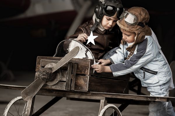 هوانوردان جوان در هواپیماهای خانگی در آشیانه بزرگ