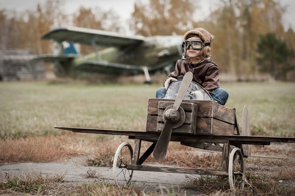 پسر جوان خلبان در هواپیما در پاییز دست ساز فرودگاه