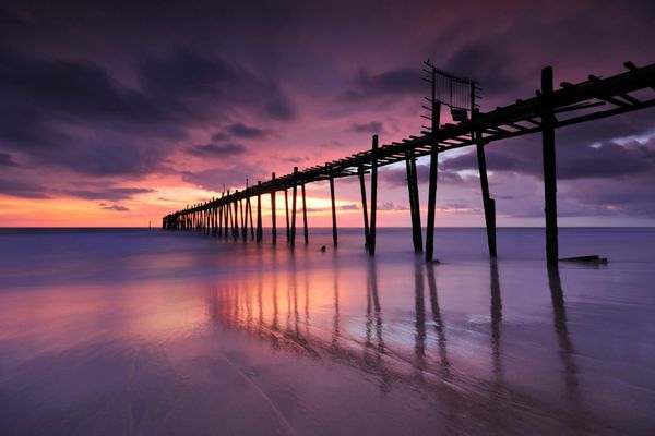 پل چوبی به دریا بعد از غروب خورشید در ساحل
