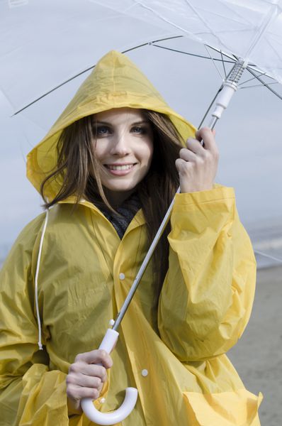 زن جوان در حال لذت بردن از یک روز بارانی