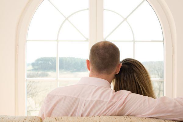 زن و شوهری که روی مبل روبروی پنجره نشسته‌اند در زمان جدید آزادی جهان
