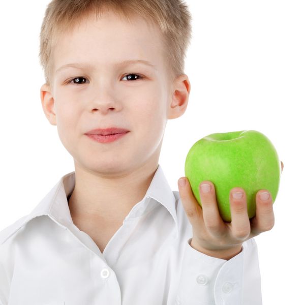 پسر کوچولوی خندان ناز در حال ارائه یک سیب سبز