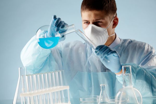 تصویر یک شیمیدان جوان در حال آزمایش مواد