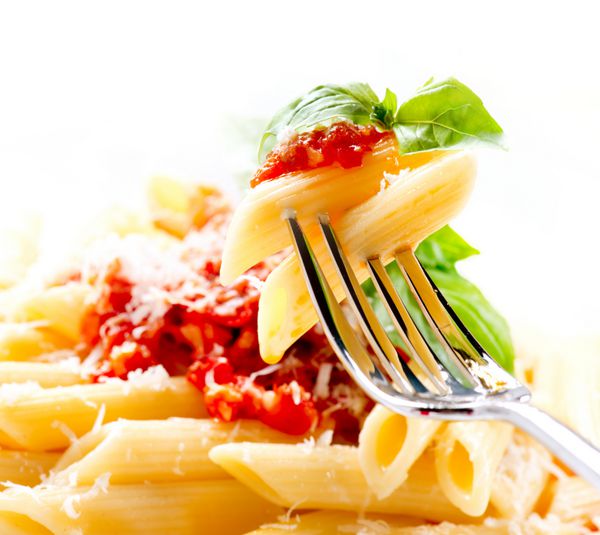 پاستا پاستا پنه با سس بولونیز پنیر پارمزان و ریحان روی چنگال غذاهای ایتالیایی غذای مدیترانه ای