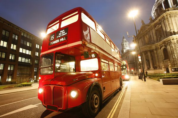 اتوبوس مسیرنمای لندن هنگام غروب و کلیسای جامع سنت پل در پس‌زمینه است