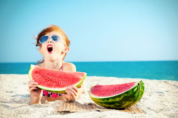 کودک شاد روی دریا با هندوانه