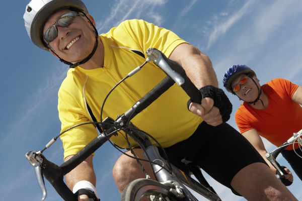 نمای پایین مردانی که در برابر آسمان دوچرخه سواری می کنند