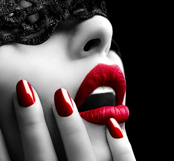 زن زیبا با ماسک سیاه روی چشمانش لب قرمز و ناخن نزدیک دهان باز مانیکور و آرایش مفهوم را تشکیل می دهد شور