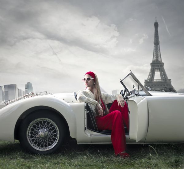 زن زیبا روی یک ماشین قدیمی در پاریس