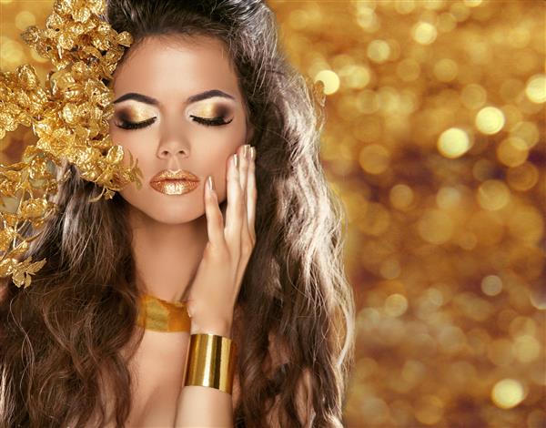پرتره دختر زیبایی مد جدا شده در پس زمینه چراغ های درخشان کریسمس طلایی آرایش زرق و برق دار جواهرات طلا مدل مو