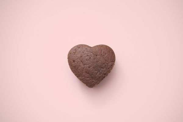 کیک شکلاتی در زمینه صورتی شکل قلب