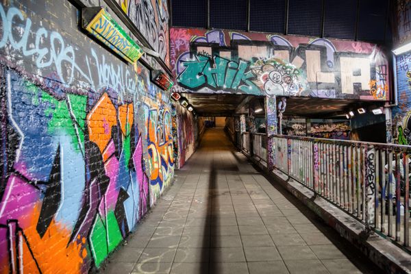 لندن بریتانیای کبیر - 18 ژانویه 2014 هنرمند ناشناس نقاشی گرافیتی و عابران پیاده در خیابان لیک لندن بریتانیای کبیر در 18 ژانویه 2014