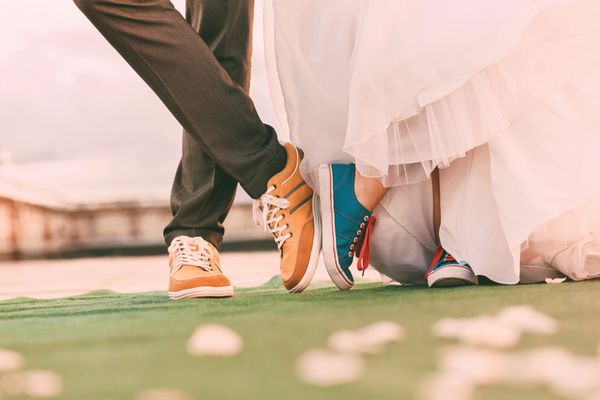 داماد و عروس با لباس های پلمسال روی فرش سبز