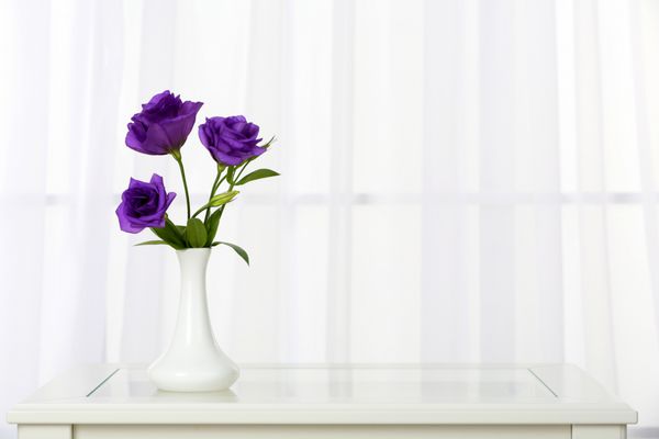 دسته گل زیبا در گلدان در پس زمینه پنجره