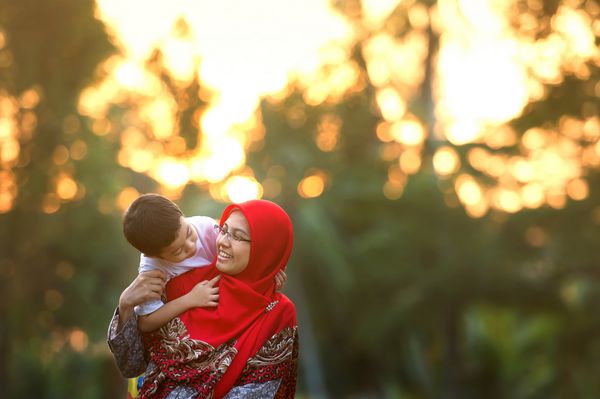 مادر شاد با پسرش در پارک تصویر رنگ آمیزی شده تمرکز انتخابی