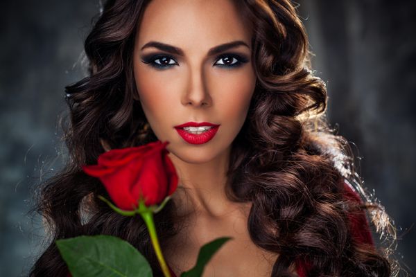 پرتره مد زن جوان با گل رز قرمز