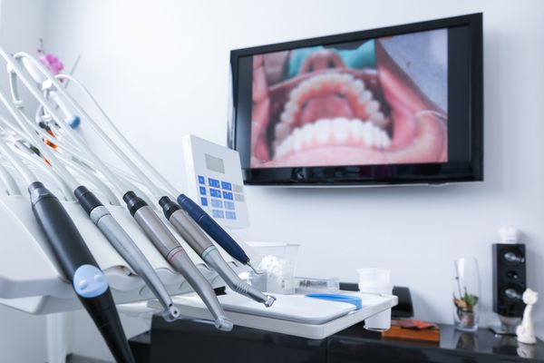 مطب دندانپزشکی - ابزار تخصصی مته هندپیس و لیزر با تصویر زنده از دندان ها در پس زمینه مفهوم مراقبت از دندان بهداشت دندان چکاپ و درمان