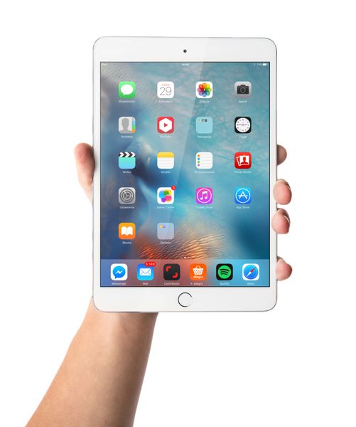 کراکو - 28 آگوست دست مردی که شبکیه چشم iPad mini 3 جدا شده روی پس زمینه سفید را در دست گرفته است لهستان در 28 آگوست 2015