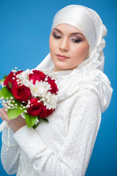 دختر شاد اسلامی که یک دسته گل در دست دارد